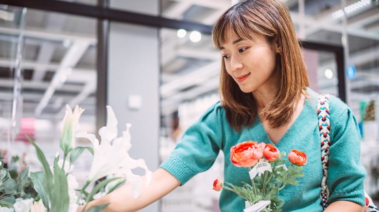 Woman picking out an artificial flower for a DIY project