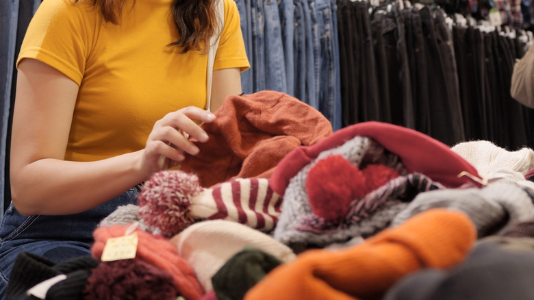 Close-up of person at the thrift store grabbing fabrics.