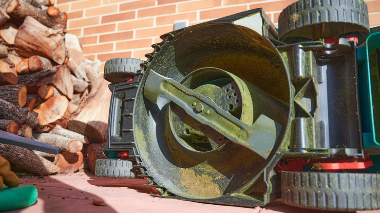 A mower turned on its side for blade sharpening