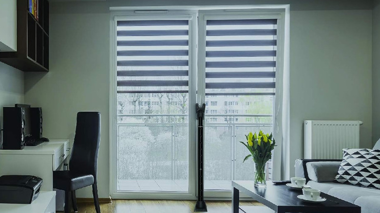 A portable door brace against double glass doors.