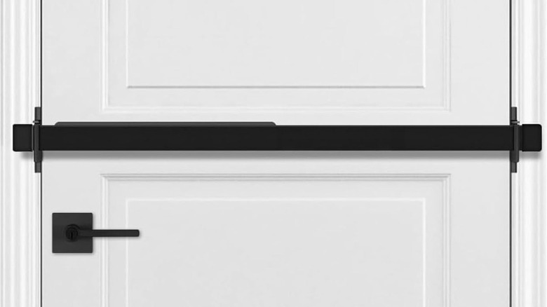 A black permanent door brace bar across a white door.