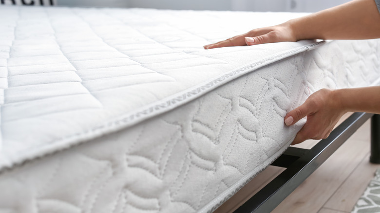 hands lifting mattress