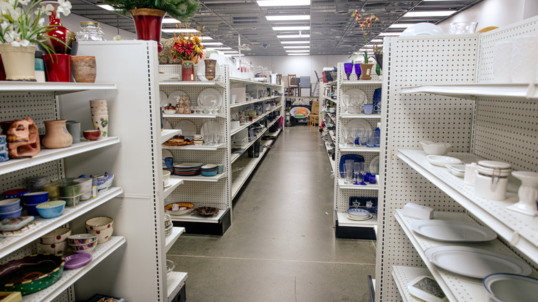 Thrift store dinnerware aisle with various vintage dishes