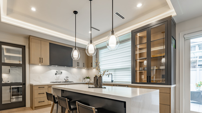 Three modern pendant lights hanging over a kitchen island