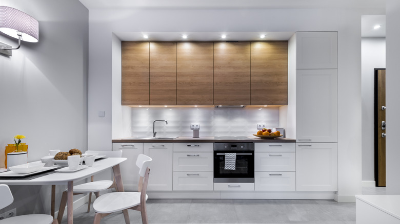 A modern white kitchen with wood accents