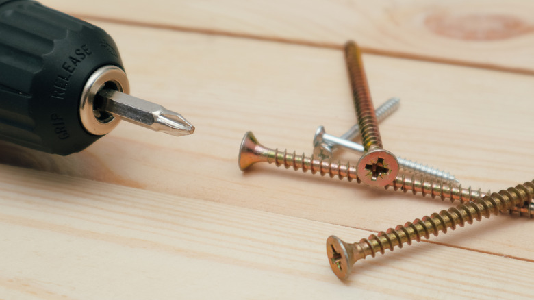 Drill driver and screws to fix a hardwood floor