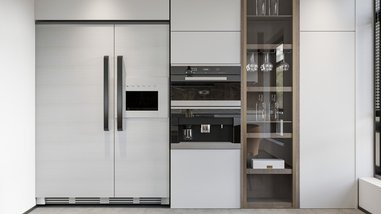 Modern kitchen with built-in refrigerator, oven, and coffee machine