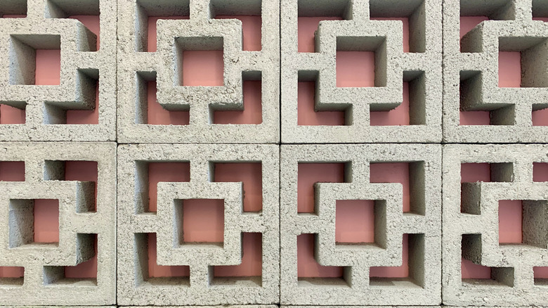 wall of gray breeze blocks with pink background