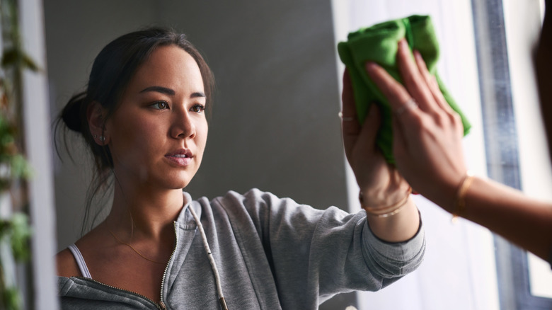 Woman cleaning a mirror