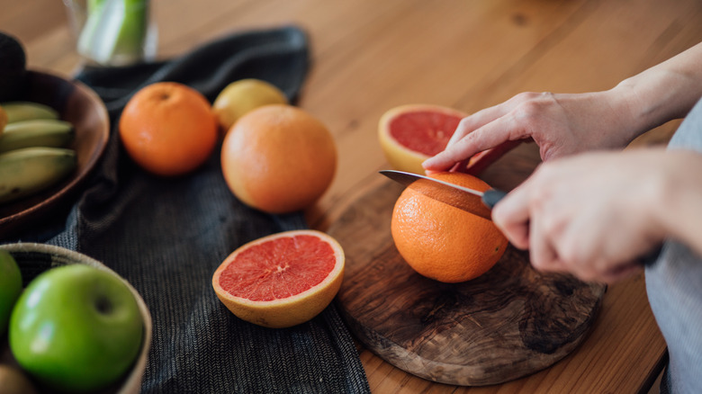 Person cutting grapefruits in halves
