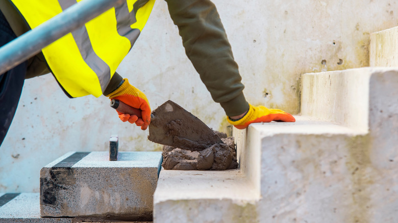 Concrete steps under construction as a team of builders install heavy concrete blocks.
