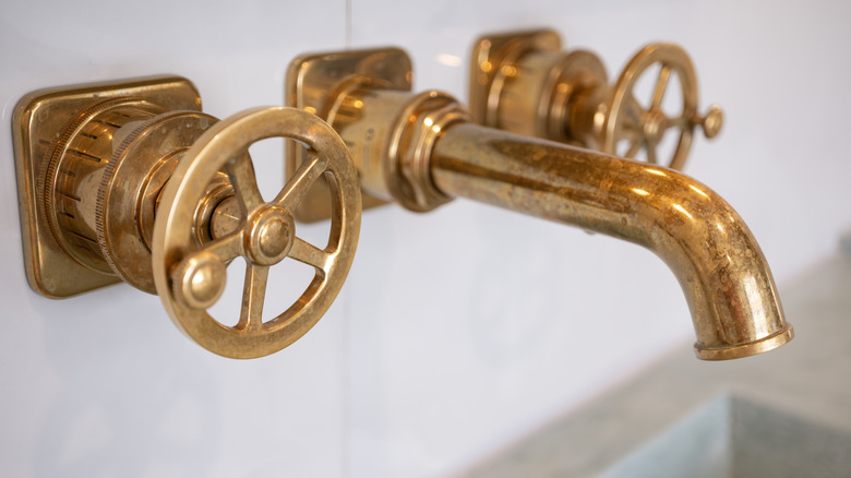 close-up image of a brass faucet and knobs