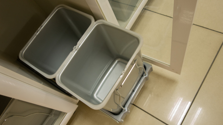two gray plastic bins on a pull out rail