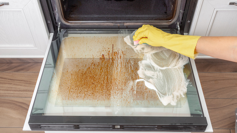 Someone cleaning oven door