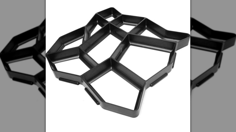 A black paving stone mold set against a white backdrop.