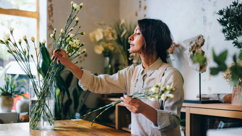 A person holding cut flower stems for an arrangement