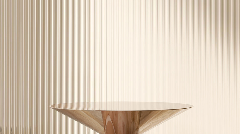 Reeded glass wall behind a gold table.