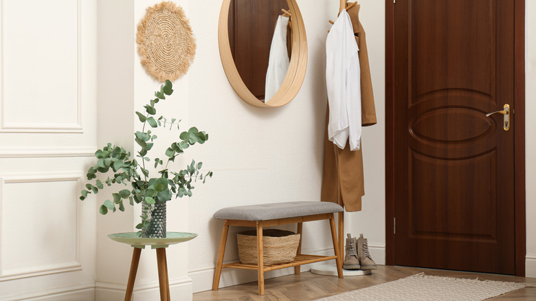 An entryway with a small, padded bench