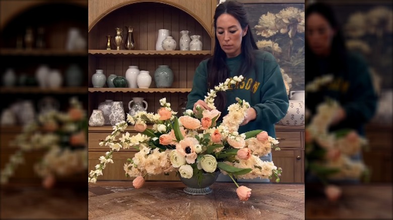 Joanna Gaines arranging artificial flowers in a vase
