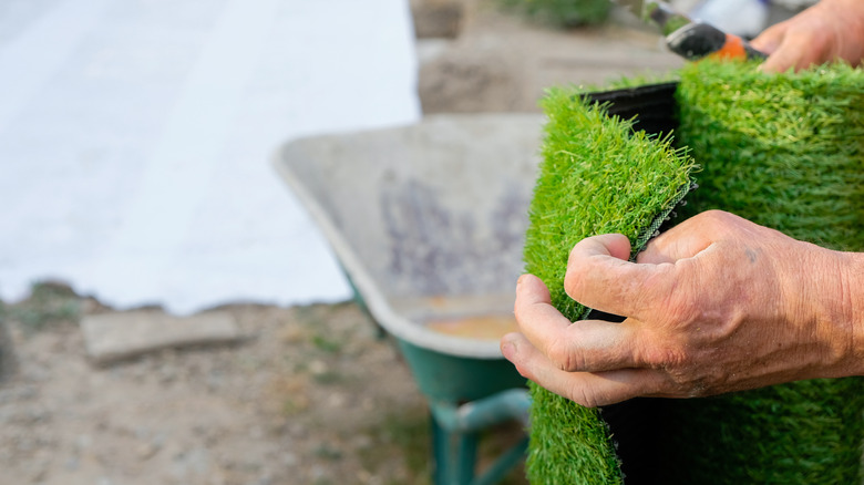 hand holding artificial grass roll