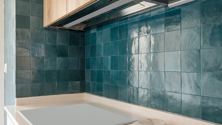 Closeup of a lovely green tiled backsplash with matching grout