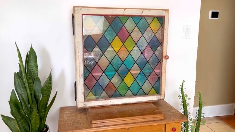 DIY bathroom cabinet made from old window sitting on wood table
