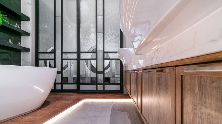 Stained lower bathroom cabinets that match the floor under the tub