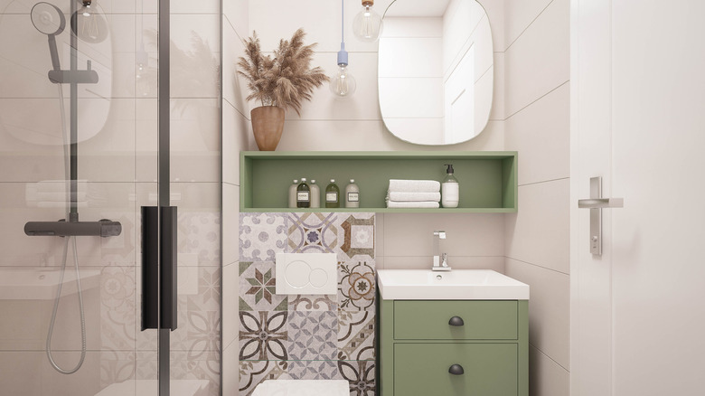Small bathroom with green shelves and cabinets