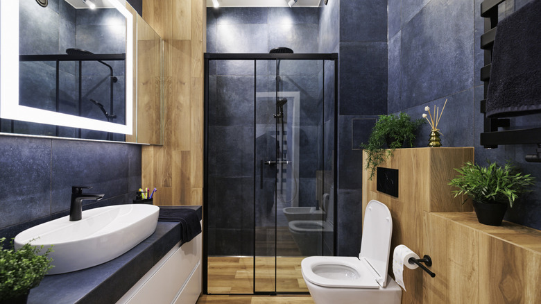 A bathroom with blue walls and wood accents