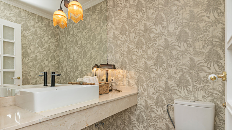 Bathroom design with busy wallpaper and mixed metals.
