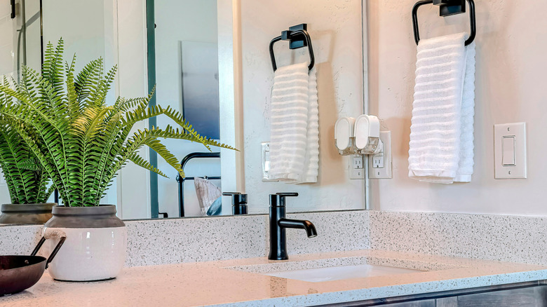 A homeowner can't find a place for a folded towel because two sinks clutter a small bathroom.