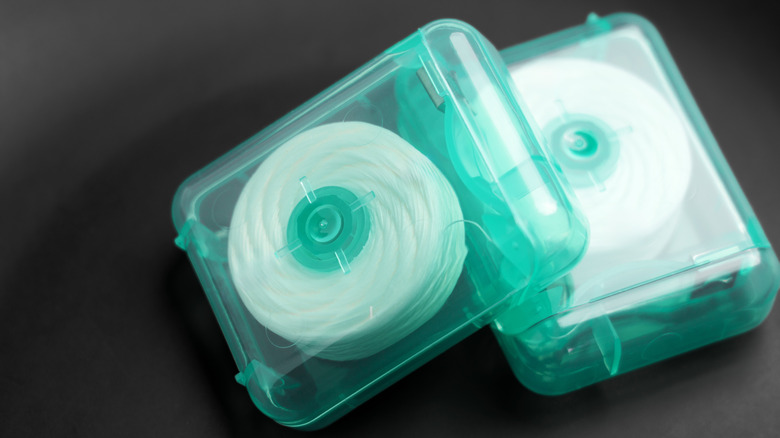 Two clear containers of dental floss