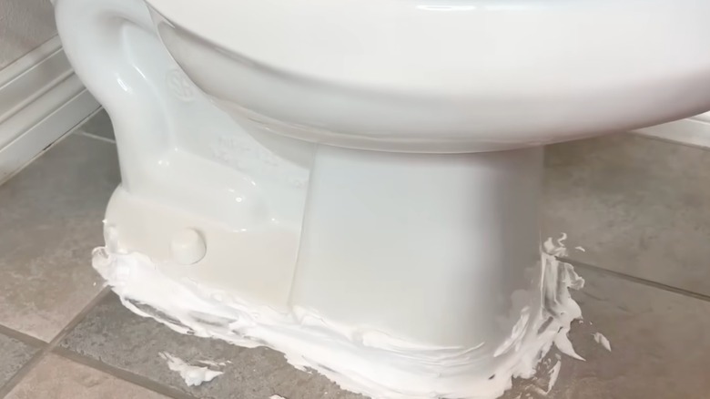Shaving cream spread on the bottom of toilet.