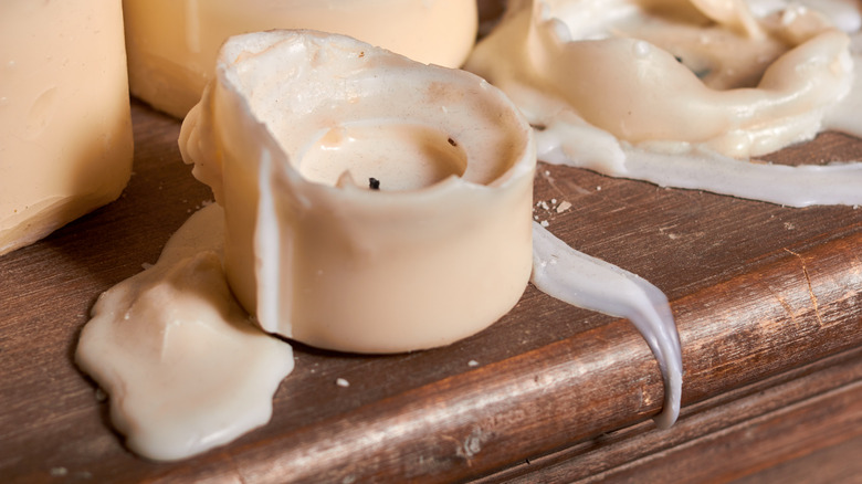 Candle with melted wax on table