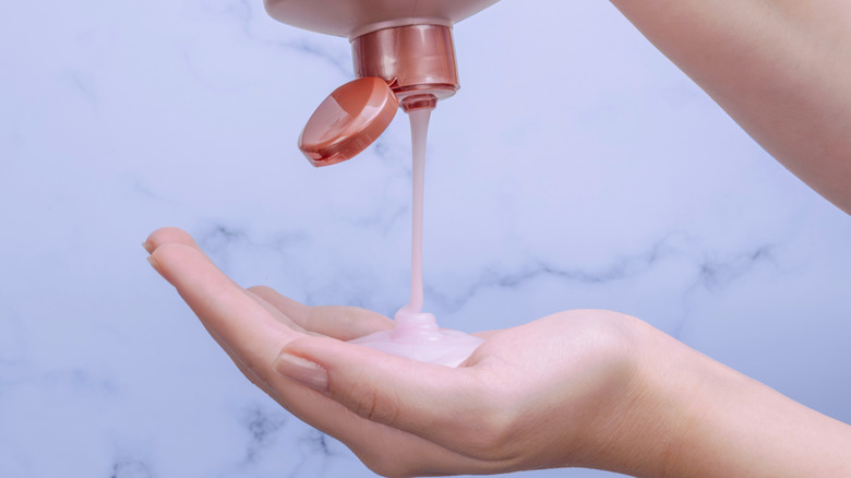 Squeezing shampoo into one's hand