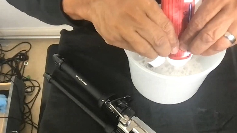 Person adding toothpaste to a cleaning solution for a curling iron