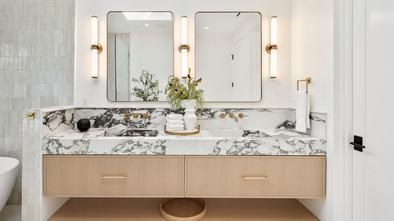 A light-filled, modern bathroom vanity with marble countertops