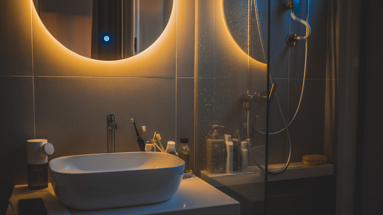 A dim, moody bathroom lit by a mirror light