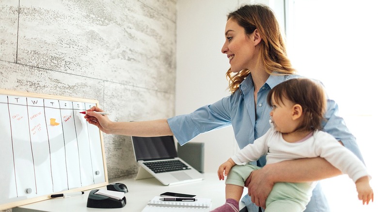 Person holding baby, whiteboard writing