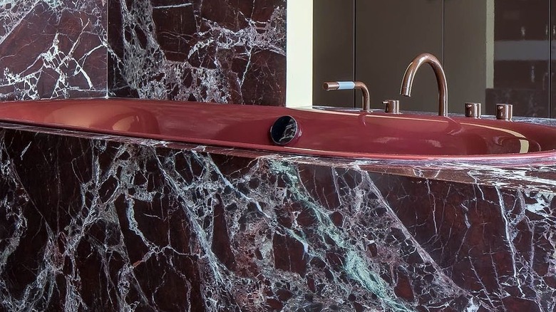A red marble sink in a bathroom