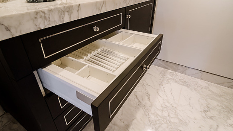 An open bathroom vanity drawer with internal storage organizers