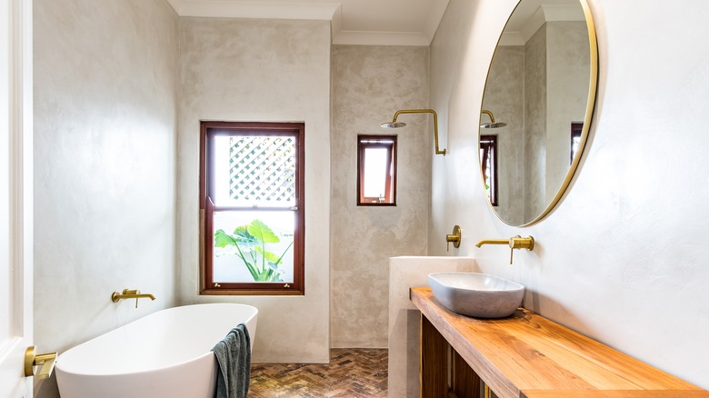 Venetian plaster wall finish inside a bathroom with a tub and shower..