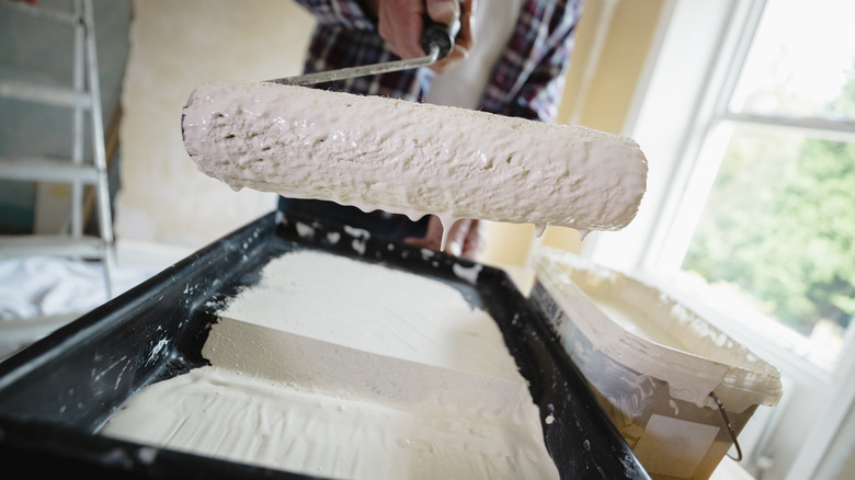 man holding wet paint roller