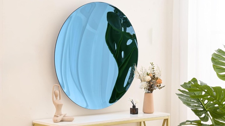 Convex wall mirror above a console table with decor