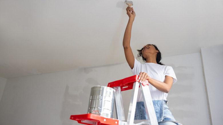 woman painting celing