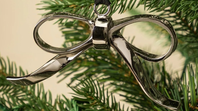 A closeup of a lovely silver bow tree ornament on a branch