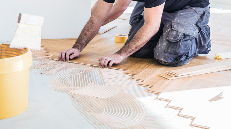 Man laying wood flooring