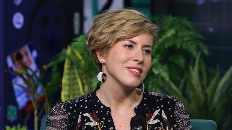 Erin Napier holding microphone in front of blurred fern