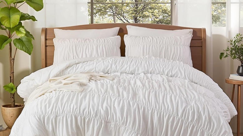 Ruched white bedding on a king size bed.