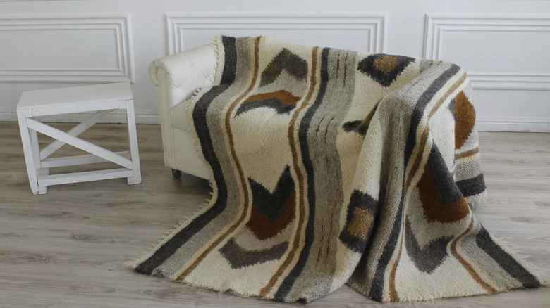A neutral wool Scandinavian quilt draped over a couch